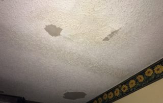water damage restoration miami working on a damaged ceiling